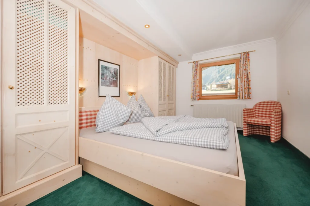 Schlafzimmer mit Doppelbett im Appartement Wasserfall – Edenlehengut in Krimml