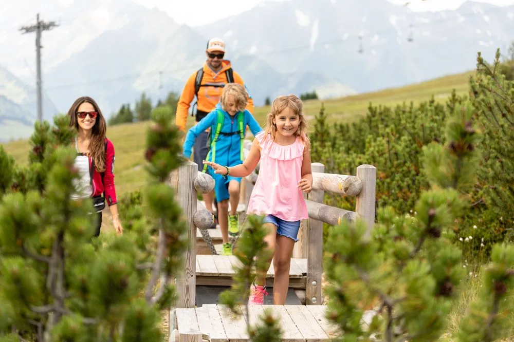 Familie beim Wandern auf dem Holzsteg – Edenlehengut in Krimml