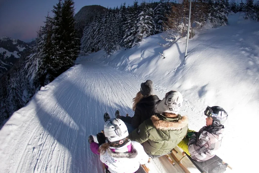 Rodler auf der verschneiten Rodelbahn bei der Filzsteinalm – Edenlehengut in Krimml